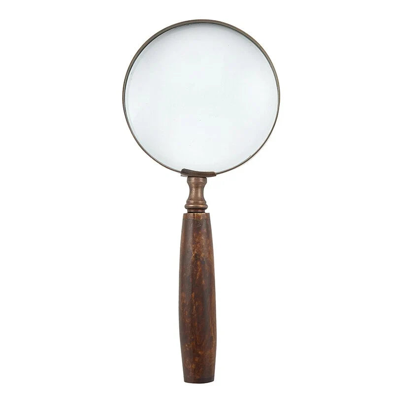 A classic magnifying glass with a large circular clear lens, a dark metal rim, and a long, contoured brown wooden handle, shown against a plain white background.
