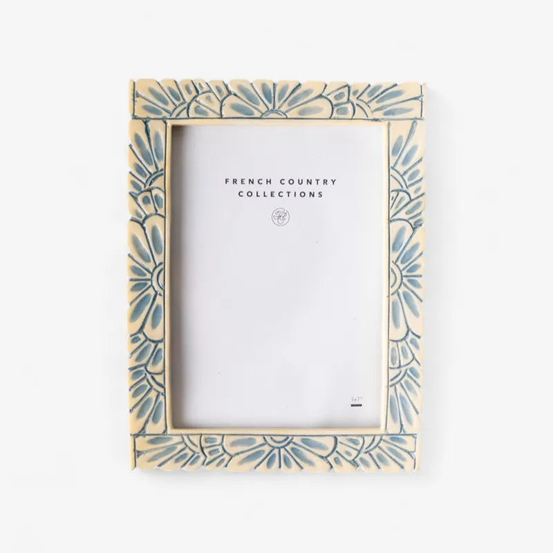 Decorative cream picture frame with a blue floral pattern on a white background
