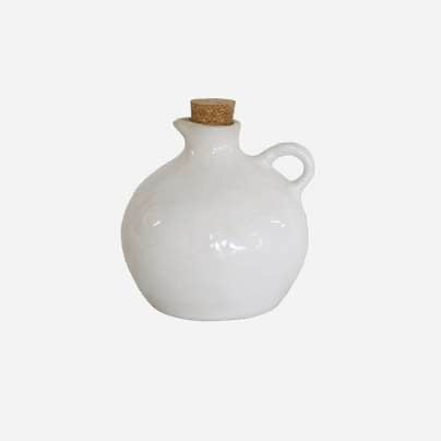 White ceramic jug with cork stopper on a white background