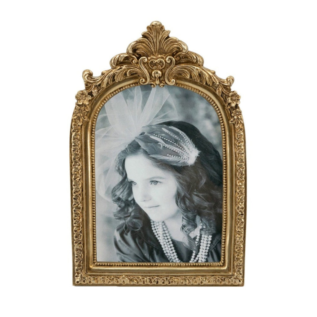Vintage-style gold frame with a black and white photo of a young girl wearing a tiara and pearls.