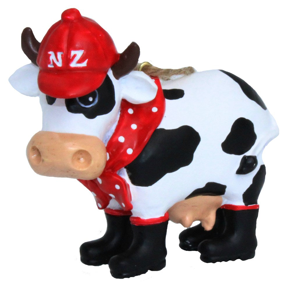 Black ad white cow wearing gumboots and a red hat with NZ on it