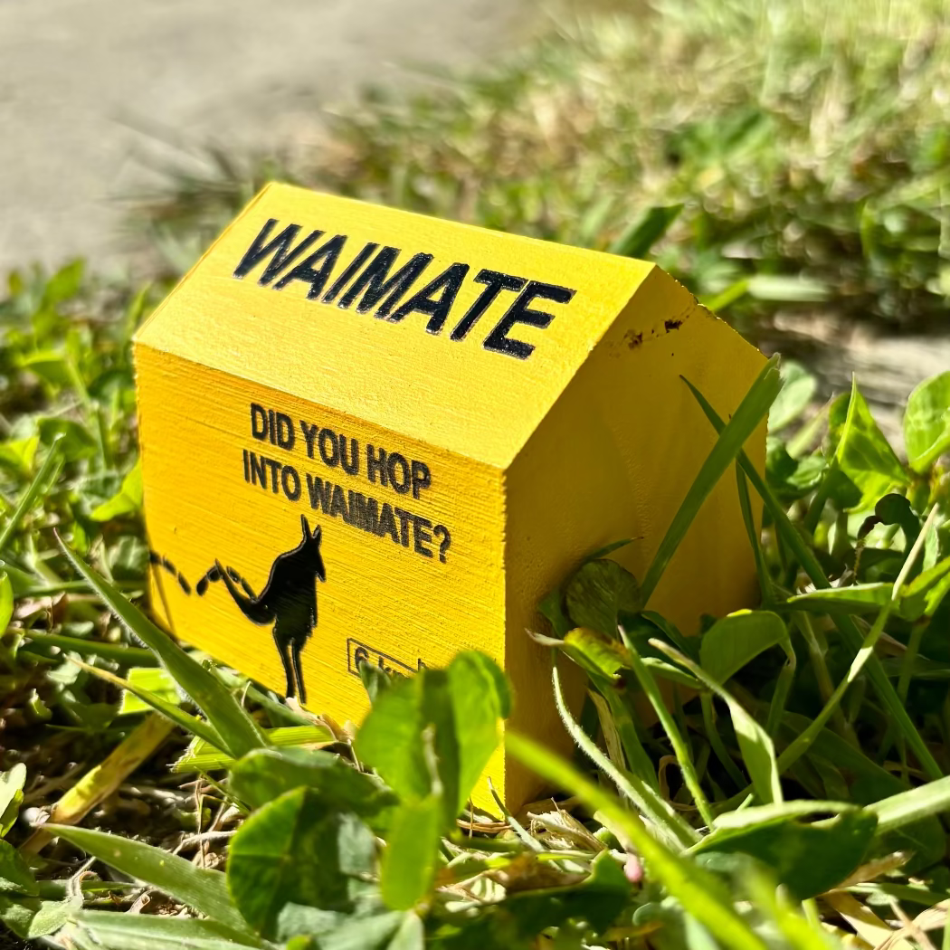 Yellow house-shaped sign with 'Waimate' text and a wallaby graphic on grass