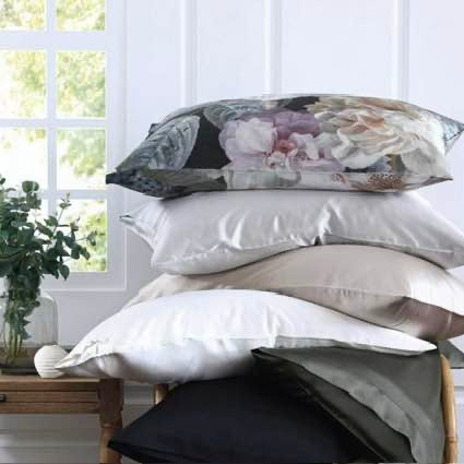 Stack of pillows with floral design, Floz, on top, against a light background