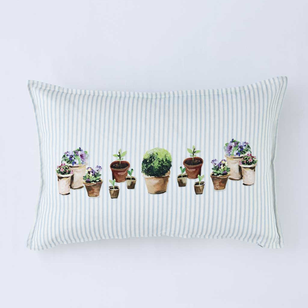A rectangular throw pillow with a white and light green vertical stripe pattern, featuring a central watercolor-style illustration of various potted plants and flowers.
