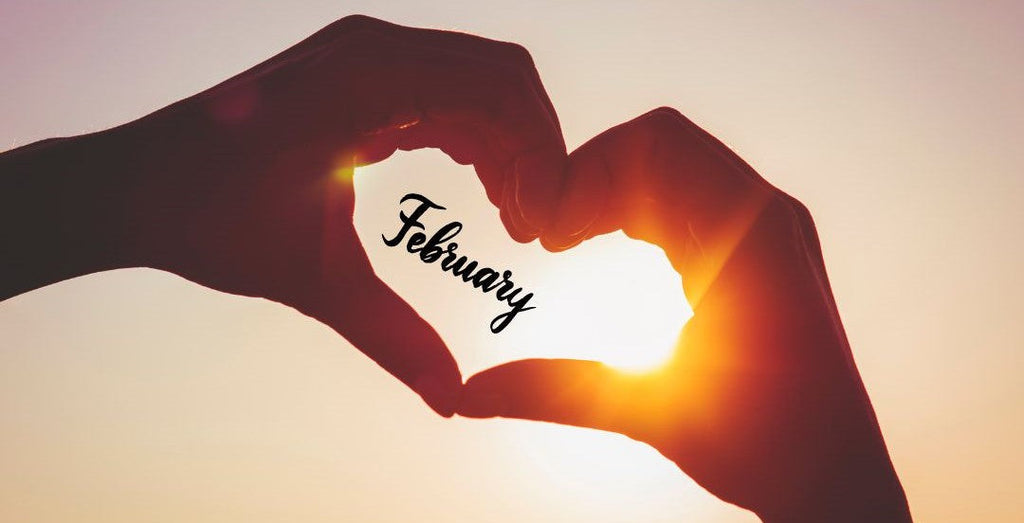 February is the month for love, hands creating the shape of a heart containing the word February.