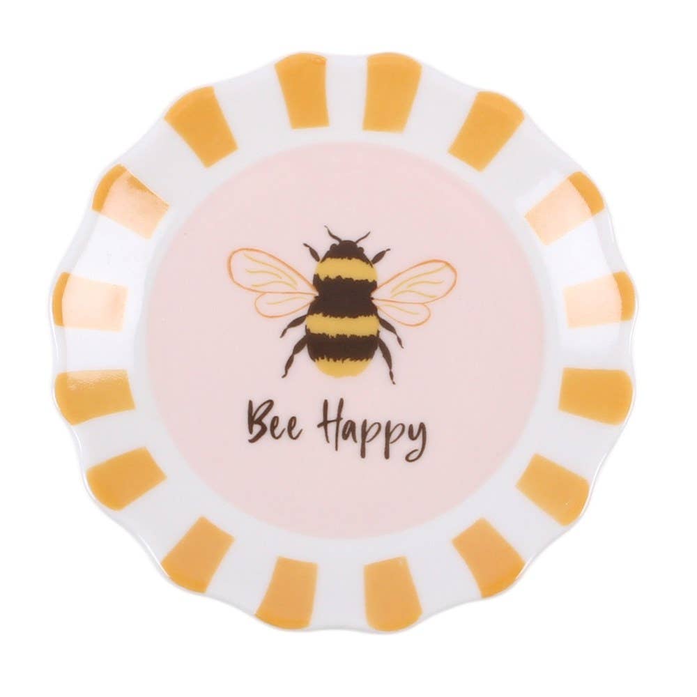 A round decorative plate with a scalloped edge, featuring a light pink center printed with a bumblebee and the words 'Bee Happy', surrounded by alternating white and yellow stripes.