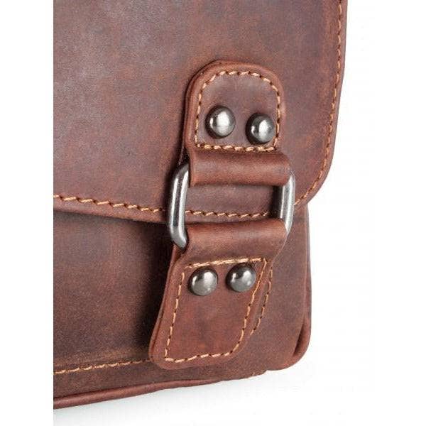 Close-up of a brown leather bag with metal buckles on a white background