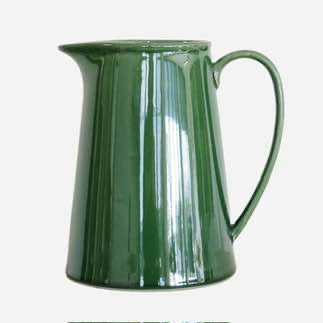 Green ceramic pitcher on a white background