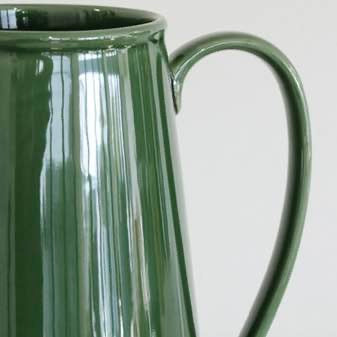 Green ceramic pitcher on a white background close up