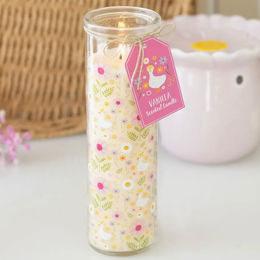 Vanilla scented candle in a glass jar with a decorative label on a light background