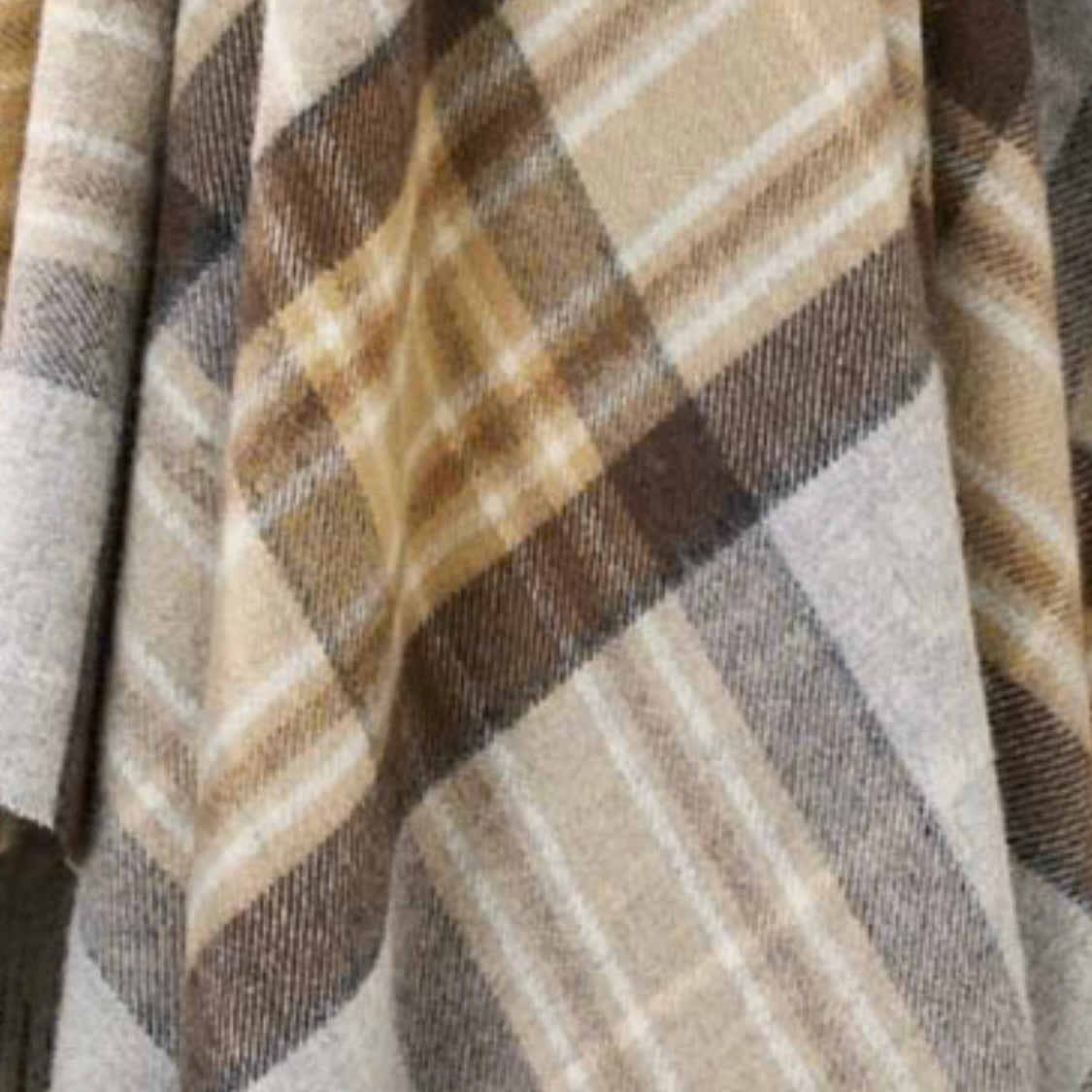Close-up of a plaid fabric with brown, beige, and gray colors.