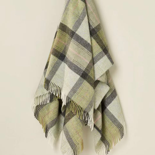 Plaid blanket with fringes on a light beige background