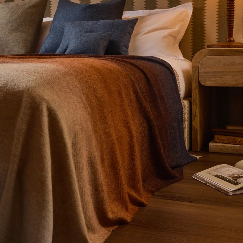 Bedroom scene with a bed, pillows, and a lamp on a nightstand.