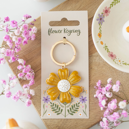 Gold flower keyring on a decorative card with flowers around