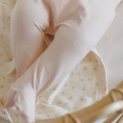 Close-up of a baby's outfit with a soft texture on a matching fabric background