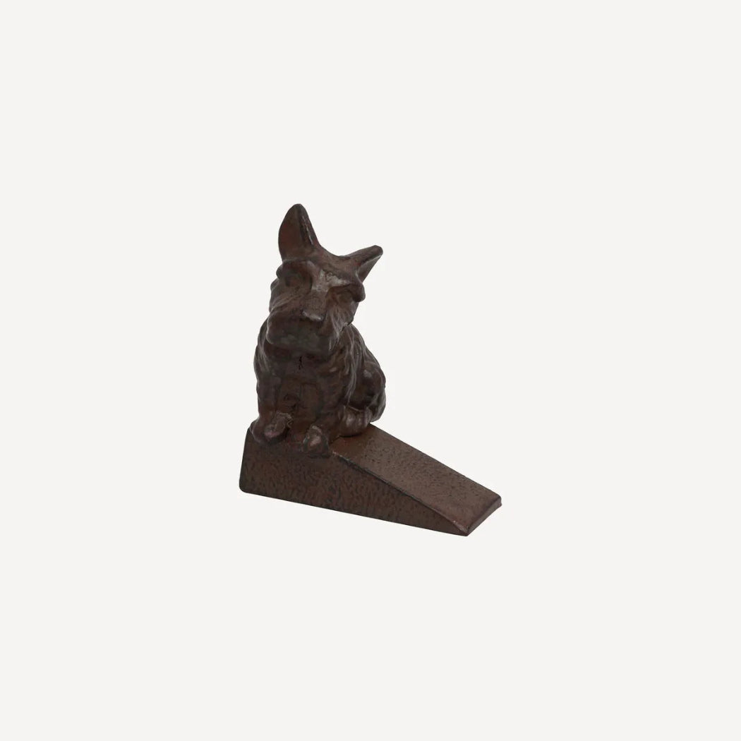 A small dark brown cast-iron dog door stopper on a white background.