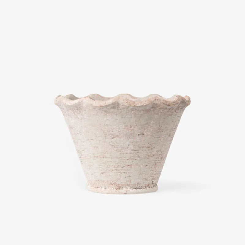 A small rustic ceramic planter with a scalloped rim, featuring a textured off-white glaze with subtle pinkish-brown speckles, set against a plain white background.