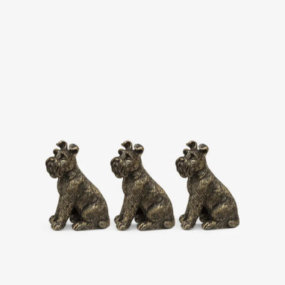 Three bronze dog figurines sitting side by side on a white background