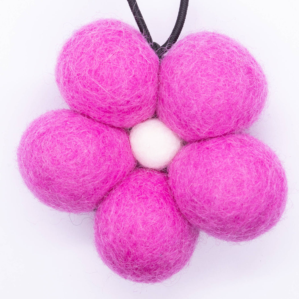 Pink felt ball flower on a white background