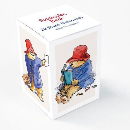 A box of Paddington Bear branded mini notecards featuring illustrations of the character Paddington with a red hat and blue coat, reading a book, and writing on a notecard. The box is white with blue and red accents and bears the text '20 Blank Notecards'.