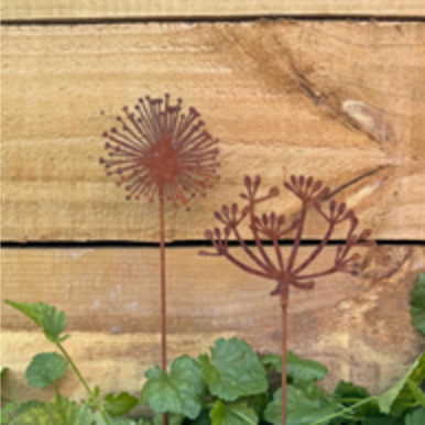 Decorative metal plant stands with a rustic design on a wooden surface.