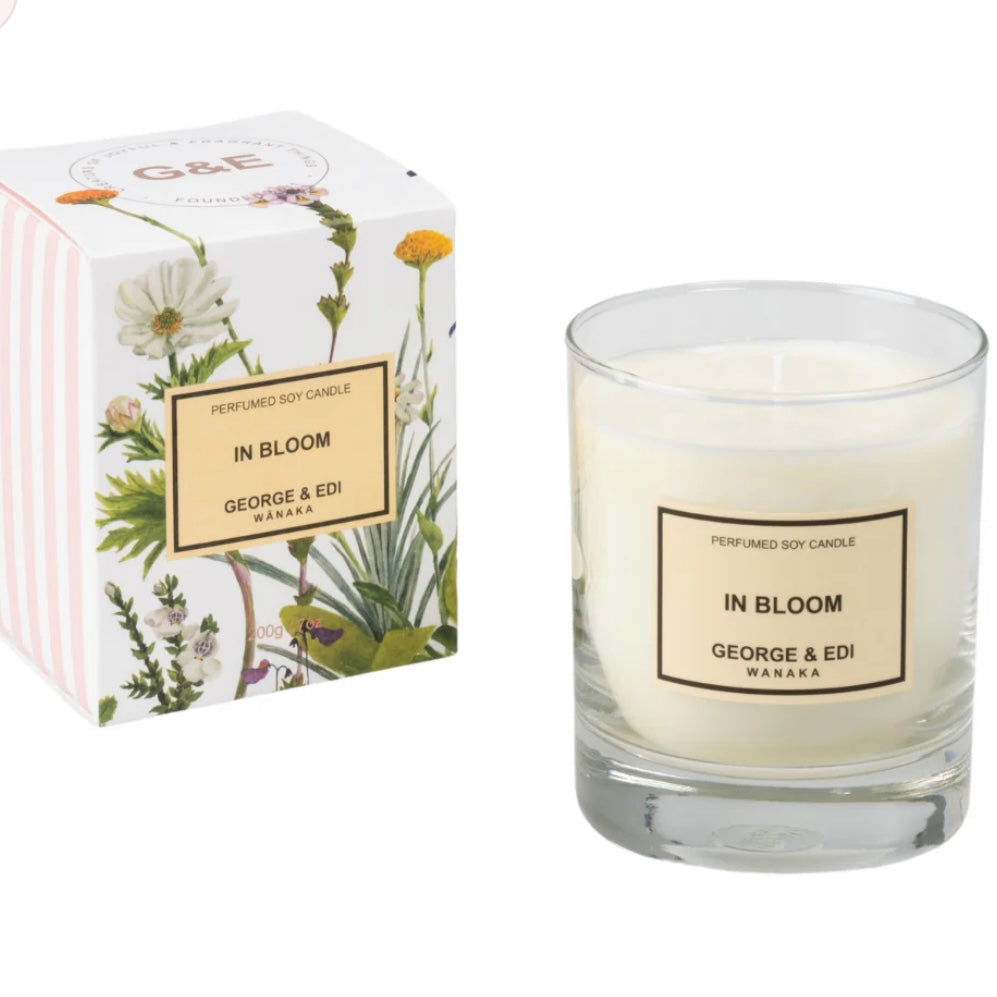 Candle labeled 'In Bloom' by George & Edi Wanaka next to its packaging on a white background