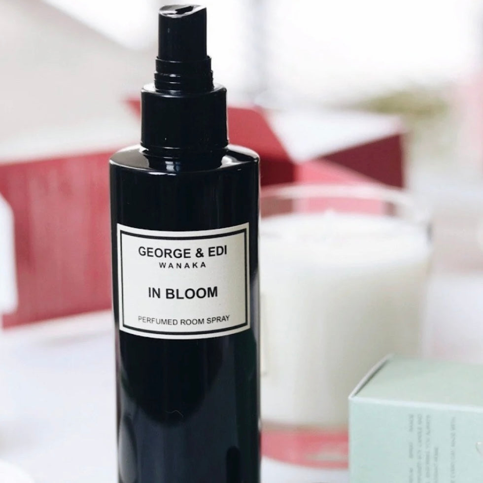 Perfumed room spray bottle labeled 'In Bloom' by George & Edi Wanaka on a blurred background.