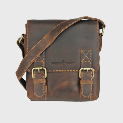Brown leather satchel bag with gold buckles on a light gray background