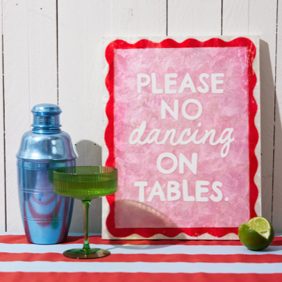Product page for a 'Please no dancing on tables' sign with a drink setup on a red and white striped tablecloth.