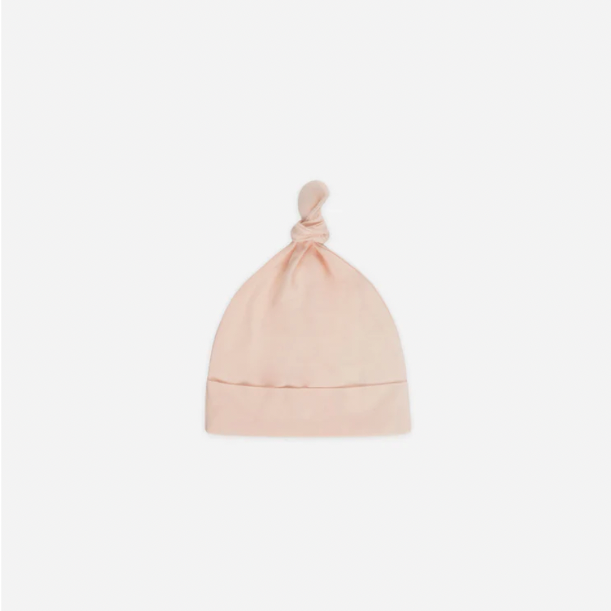 Pink baby hat with a knot on top against a white background