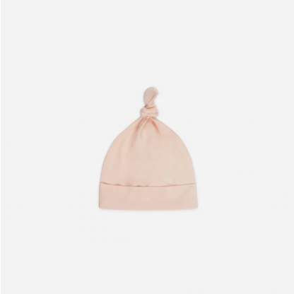 Pink baby hat with a knot on top against a white background