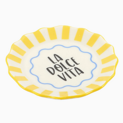 Small ceramic plate with yellow rim and 'La Dolce Vita' text on a white background