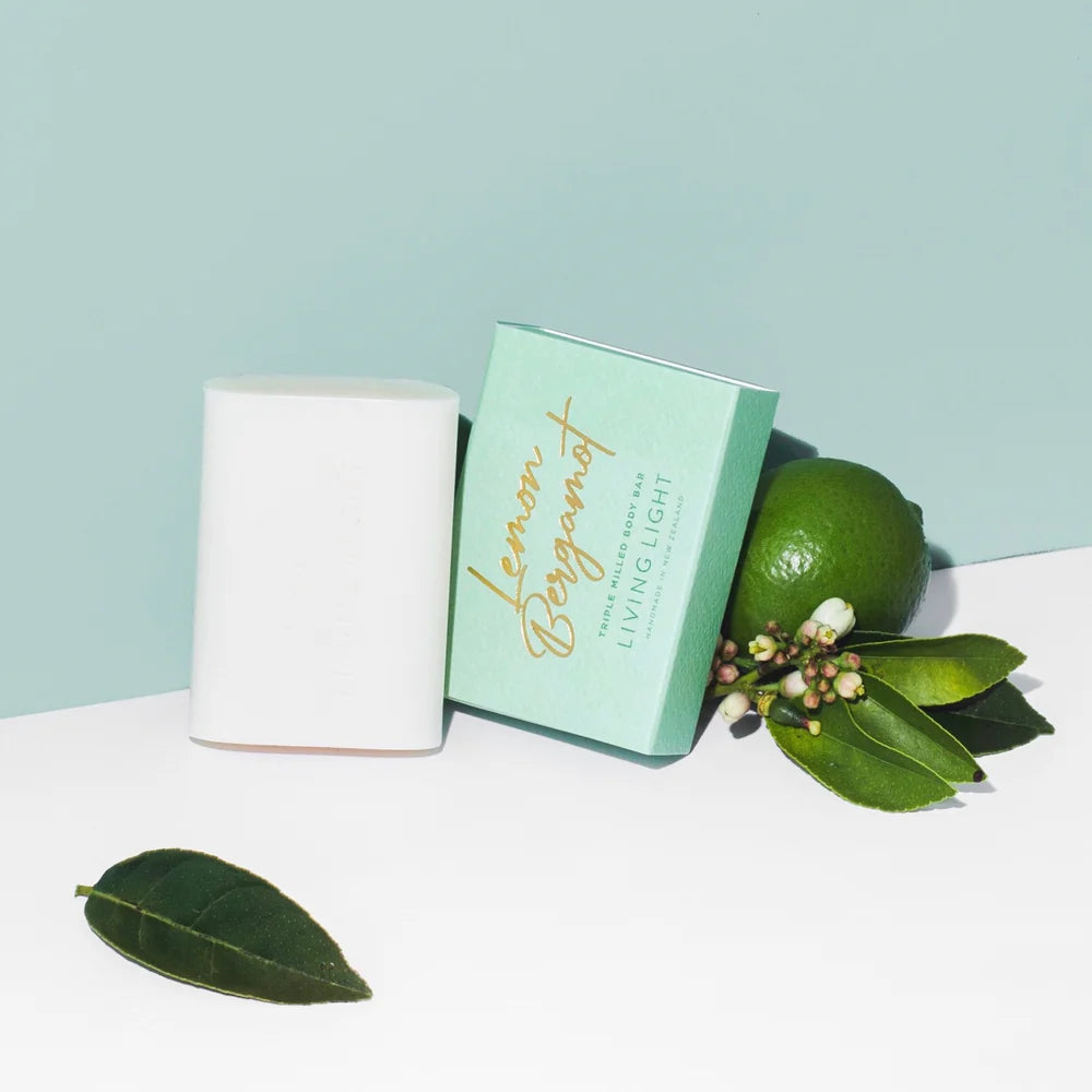 Green soap bar with 'Living Libations' branding next to a lime and leaves on a light blue background