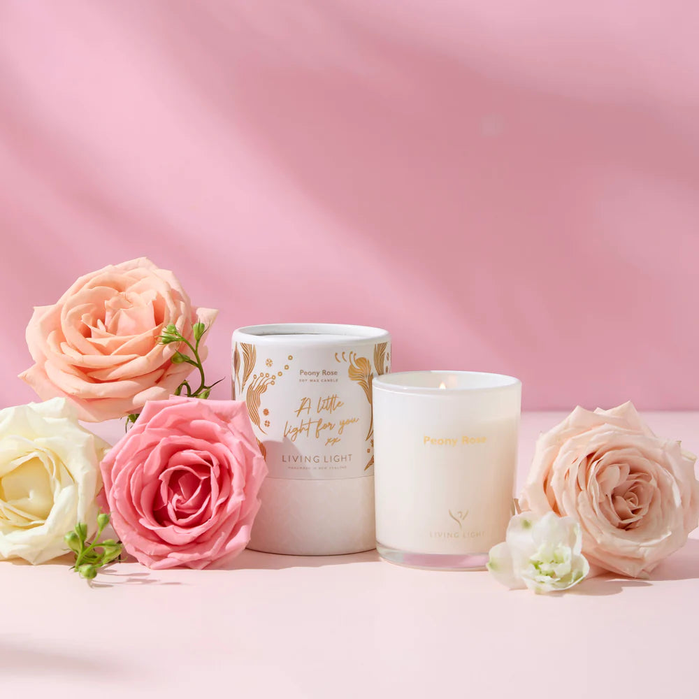 Two candles with floral designs on a pink background