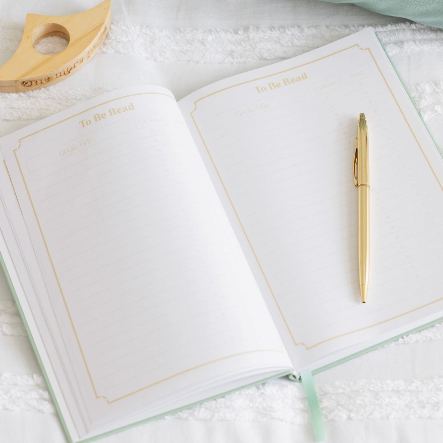 Two open notebooks with a pen on a textured surface