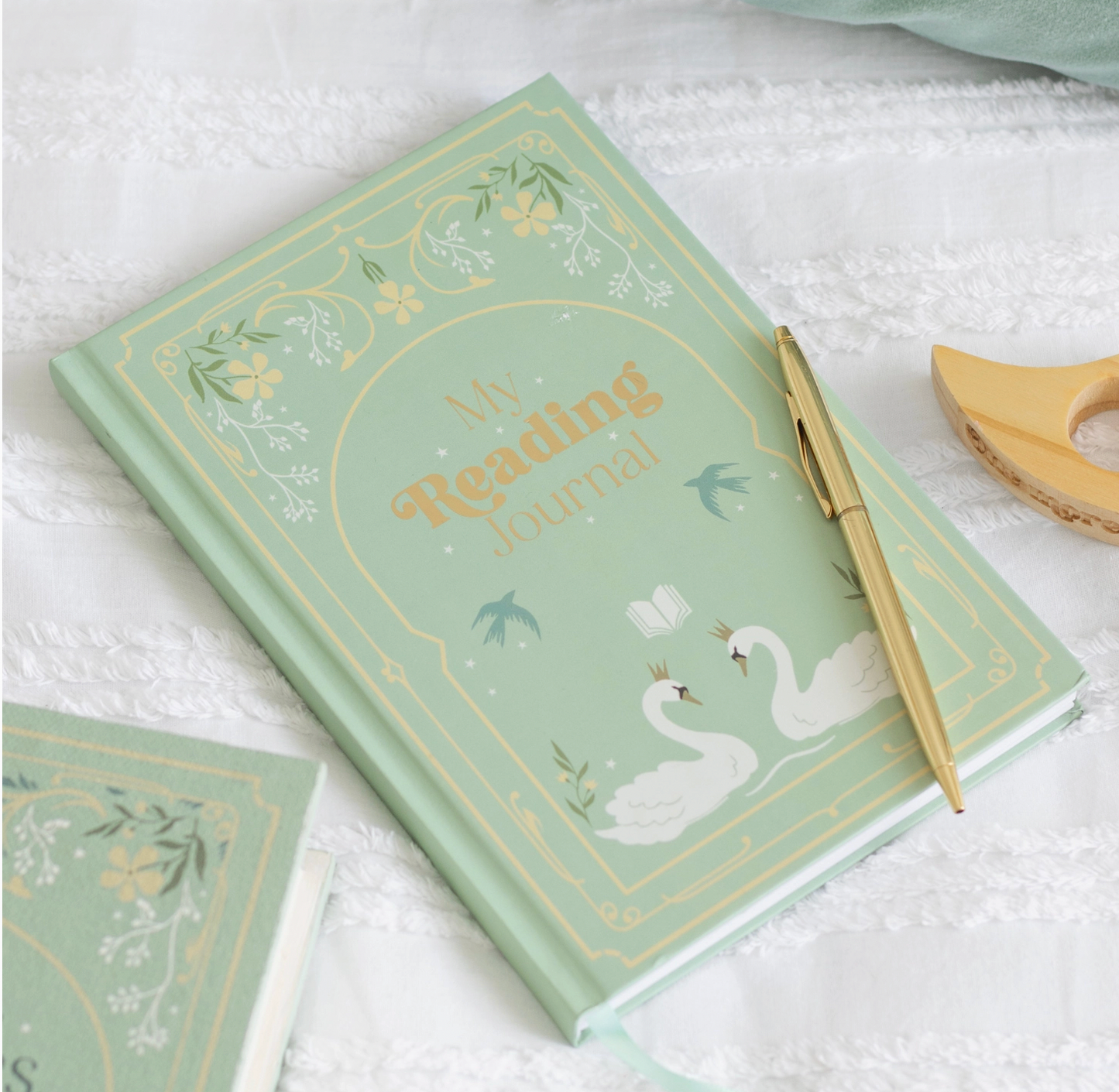 Decorative notebook with swan design and gold text on a white surface