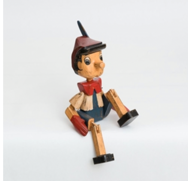 Wooden figurine of a character with a hat and boots on a white background