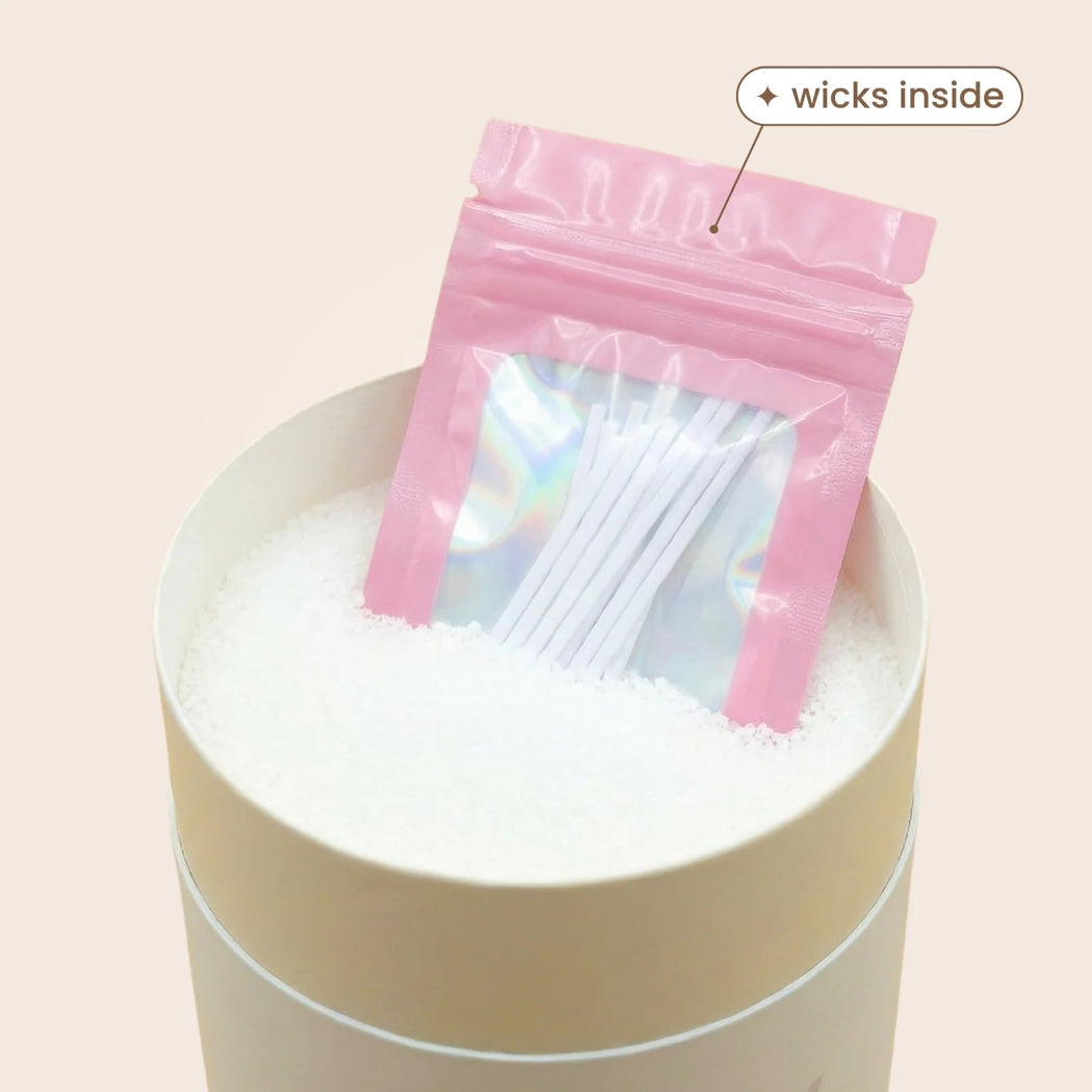 Pink packaging with wicks inside on a white container against a light pink background