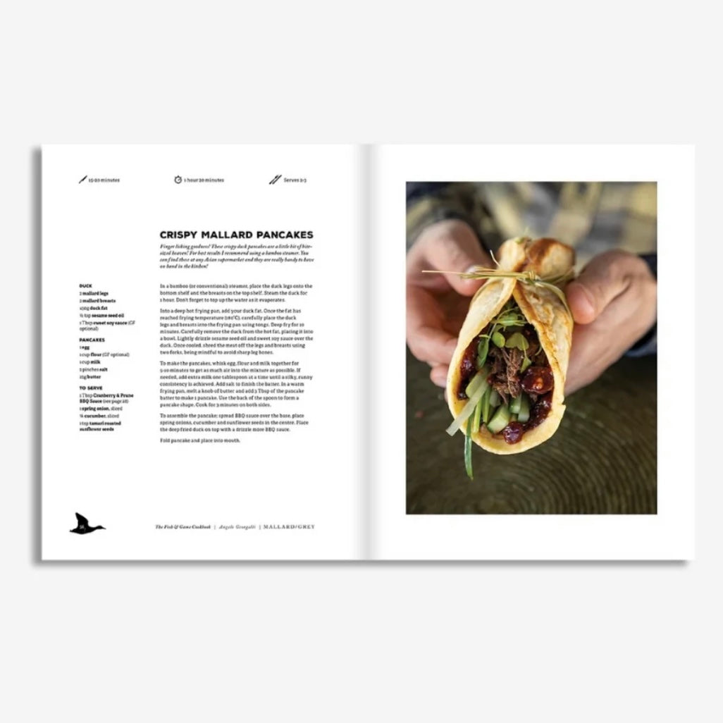 Open book showing a recipe for crispy mallard pancakes with a photo of a hand holding a wrapped dish.