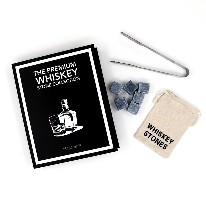 A whiskey stone collection gift set on a white background, including a black and white branded booklet, gray stone cubes, metal tongs, and a beige drawstring pouch labeled 'Whiskey Stones'.