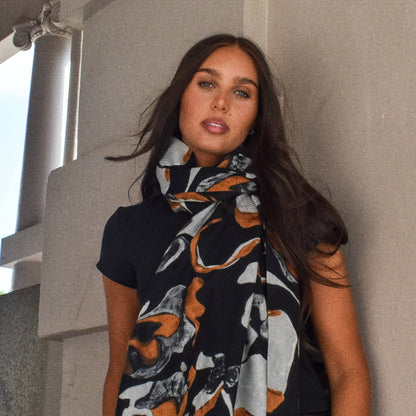 Woman wearing a patterned scarf against a neutral background