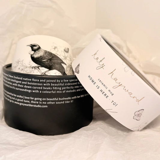 Ceramic mug with bird design and packaging on a white background