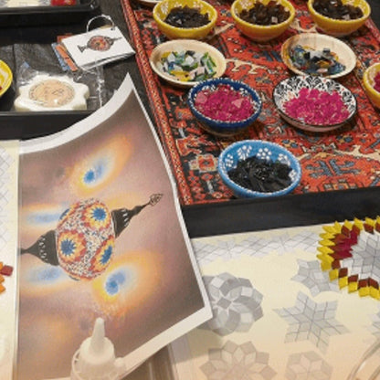 Colorful bowls with decorative items on a patterned rug, with a magazine open to a page about lanterns.