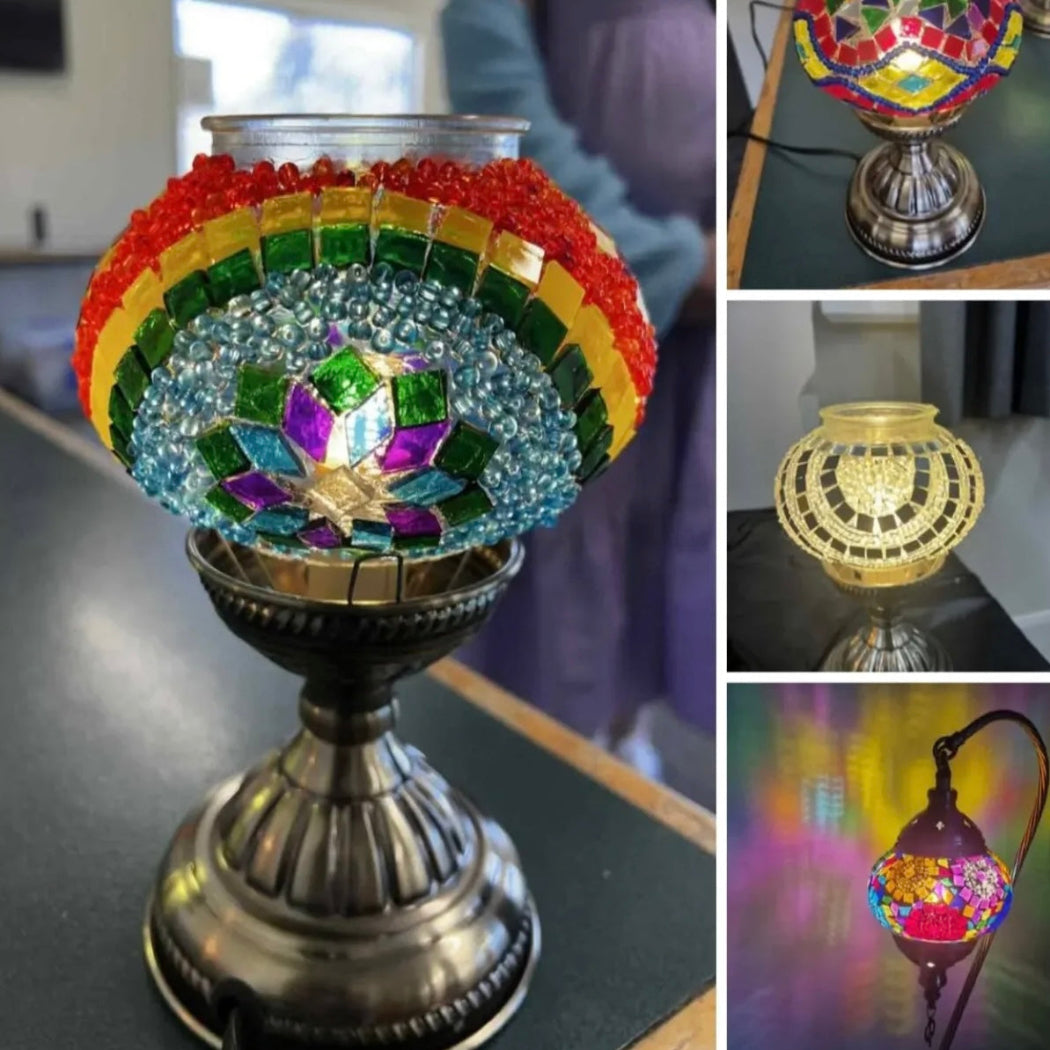 Colorful mosaic lamp with rainbow design on a reflective surface.