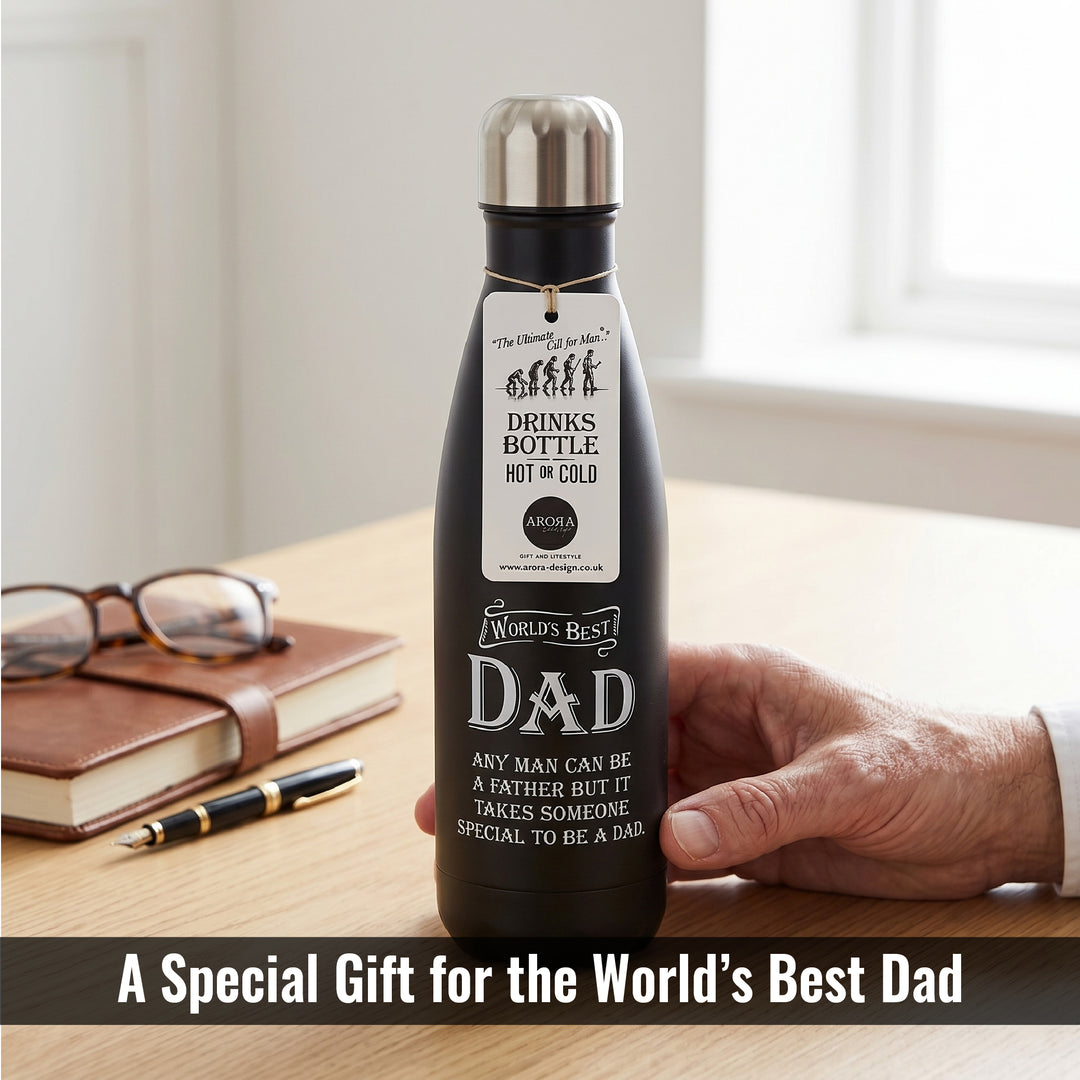 Black insulated drinks bottle with engraved message held by a hand on a wooden surface.