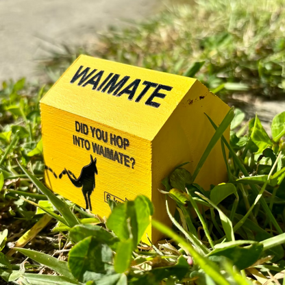 Yellow house-shaped sign with 'Waimate' text and a wallaby graphic on grass