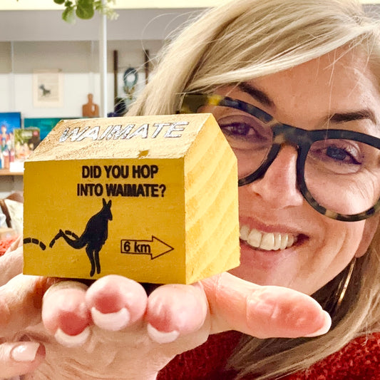 Person holding a small wooden box with 'Waimate' branding and text.