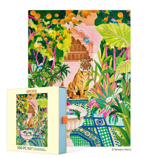 A colorful 500-piece jigsaw puzzle and its matching box shown on a white background. The puzzle features a vibrant tropical garden scene with a tiger, palm leaves, flowers, and a pink pavilion.