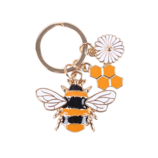 A bee-themed keychain with a gold-tone metal ring, featuring a bumblebee charm in black and orange enamel with white wing details, a white daisy charm, and orange hexagon honeycomb charms, shown on a plain white background.