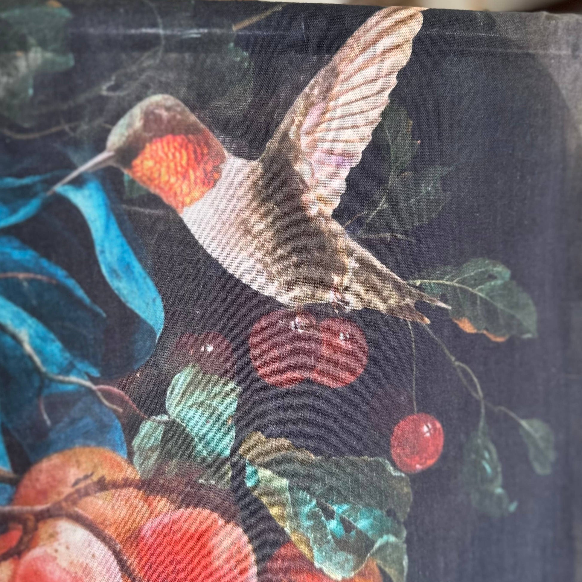 Decorative paper with a hummingbird and fruit design on a dark background